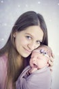 Beatific beautiful mother with long hair with beloved newborn daughter in hands Royalty Free Stock Photo