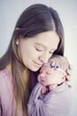 Beatific mother with long hair with beloved newborn daughter in hands Royalty Free Stock Photo