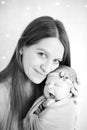 Beatific mother with long hair with beloved newborn daughter in hands Royalty Free Stock Photo