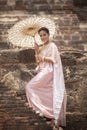 beatiful asian woman wearing thai traditon clothes style with wood umbrella toothy smiling standing in ayutthaya heritage place Royalty Free Stock Photo