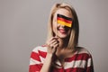 Beatiful girl holds German flag on gray background Royalty Free Stock Photo