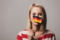 Beatiful girl holds German flag on gray background