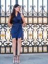Beatiful brunette woman leaning back on a palace's gate Royalty Free Stock Photo