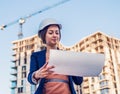 Beatiful business woman engineer is standing with plan papers. Royalty Free Stock Photo