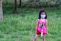 Beatiful child playing picking up flowers in a farm while wearing mask Royalty Free Stock Photo