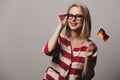 Beatiful girl in glasses holds German flag