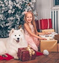 Blonde girl and white dog and New Year gift boxes Royalty Free Stock Photo