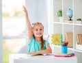 Beatiful little girl raised hand in classroom