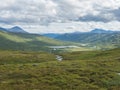 Beatiful northern landscape, tundra in Swedish Lapland with blue artic river and lake, green hills and mountains at
