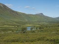 Beatiful northern landscape, tundra in Swedish Lapland with blue artic river and lake, green hills and mountains at