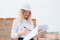 beatiful woman engineer is reviewing the plans of a construction work