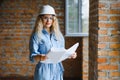 beatiful woman engineer is reviewing the plans of a construction work