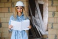 beatiful woman engineer is reviewing the plans of a construction work