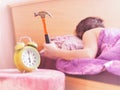 Beating the alarm clock with hammer. concept of sleep