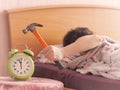 Beating the alarm clock with hammer. concept of sleep