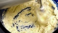 beating butter in blue bowl with mixer