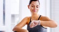 Beating the clock is what I do best. an attractive young woman checking the time on her wrist watch while working out at