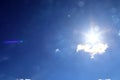 Beaufitul shots of the sun with light beams and flares on a blue sky with some clouds Royalty Free Stock Photo