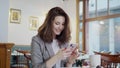 Beaufitul smiling girl with cell phone in a cafe