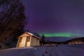 Beauitful aurora over the night sky, wooden house Royalty Free Stock Photo