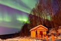 Beauitful aurora over the night sky, wooden house Royalty Free Stock Photo