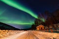 Beauitful aurora over the night sky, wooden house Royalty Free Stock Photo