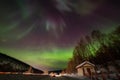 Beauitful aurora over the night sky, wooden house Royalty Free Stock Photo