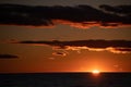 Orange sunset over lake Ontario at dusk in the evening sun setting below the horizon Royalty Free Stock Photo