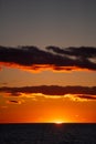 Orange sunset over lake Ontario at dusk in the evening sun setting below the horizon Royalty Free Stock Photo