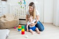 Beauitufl young woman playing with her toddler son on floor at bedroom Royalty Free Stock Photo