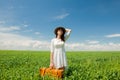 Redhead girl with suitcase standing at wheat field Royalty Free Stock Photo