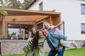 Beautfiul young family standing in front their family home, enjoying together time.