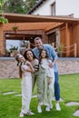 Beautfiul young family standing in front their family home, enjoying together time.