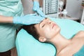 Beautician applies face cream on beautiful young woman in Spa salon. cosmetic procedure skin care. Royalty Free Stock Photo