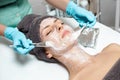 Beautician applies face mask on beautiful young woman in Spa salon. cosmetic procedure skin care. Microdermabrasion Royalty Free Stock Photo