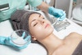 Beautician applies face mask with brush to beautiful young woman in Spa salon. cosmetic procedure skin care. Royalty Free Stock Photo
