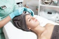 Beautician applies face mask with brush to beautiful young woman in Spa salon. cosmetic procedure skin care. Royalty Free Stock Photo