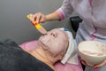 Beautician apply an alginate mask on the client`s face
