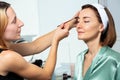 Beautician apply mascara using eyebrow brush on a woman& x27;s face