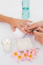 Beautician applying nail varnish to female client's nails Royalty Free Stock Photo