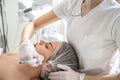 Beautician applying Radio frequency skin tightening treatment on woman& x27;s face with special device in beauty salon Royalty Free Stock Photo