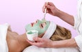 Beautician applying a thalasso face mask.