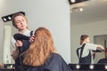 Beautician blow dry woman`s hair at beauty salon