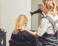 Beautician blow dry woman`s hair at beauty salon