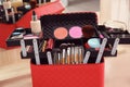Beautician case with professional makeup products and tools on wooden table Royalty Free Stock Photo