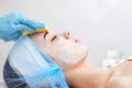 beautician cleanses skin of beautiful woman with a sponge. Royalty Free Stock Photo