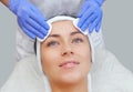 Beautician cleanses the skin on the face from acne and blackheads on the woman`s face in a beauty salon.Treatment of problem skin