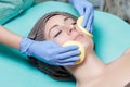 Beautician cleanses skin woman with sponge. Perfect cleaning - c Royalty Free Stock Photo