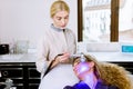 Beautician doctor doing blue led light therapy to female customer in beauty salon, facial photo therapy for skin pore