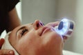 Beautician doing led light therapy to woman with problematic skin in SPA Royalty Free Stock Photo